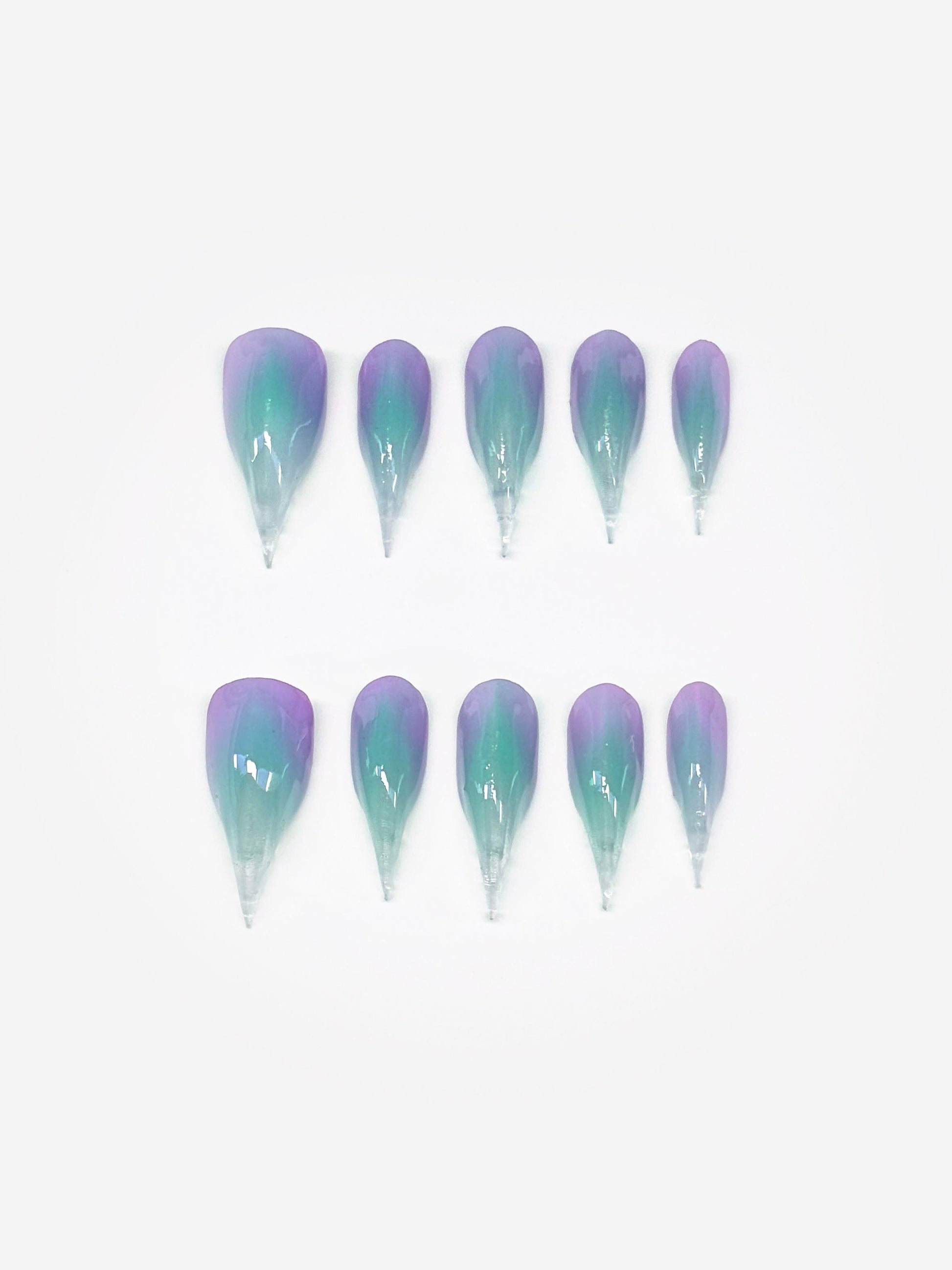 A set of 3D claw art nails, painted in gradient hues of aqua, lavender, and pink. Claw nail set display.