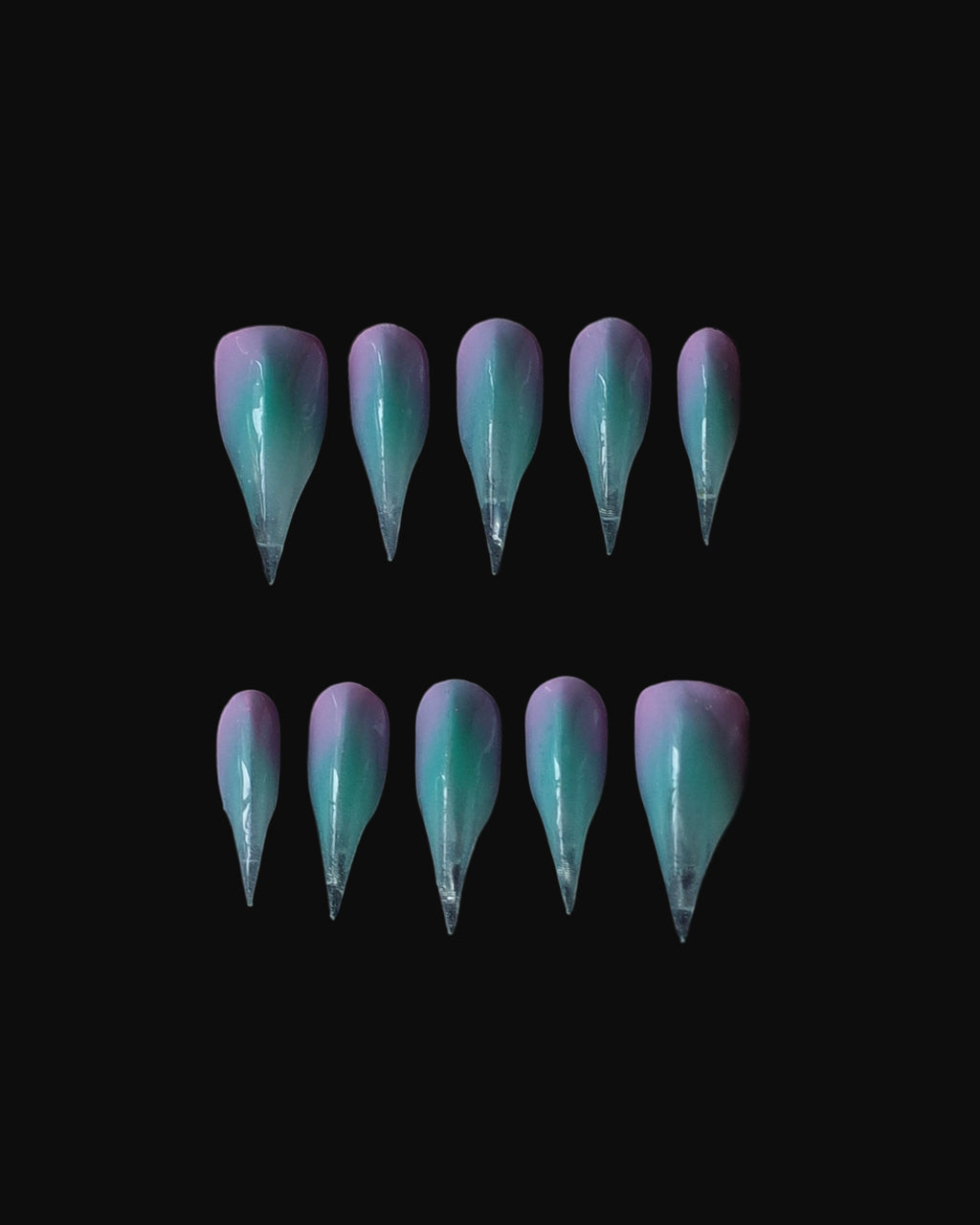 A set of 3D claw art nails, painted in gradient hues of aqua, lavender, and pink. Claw nail set display.