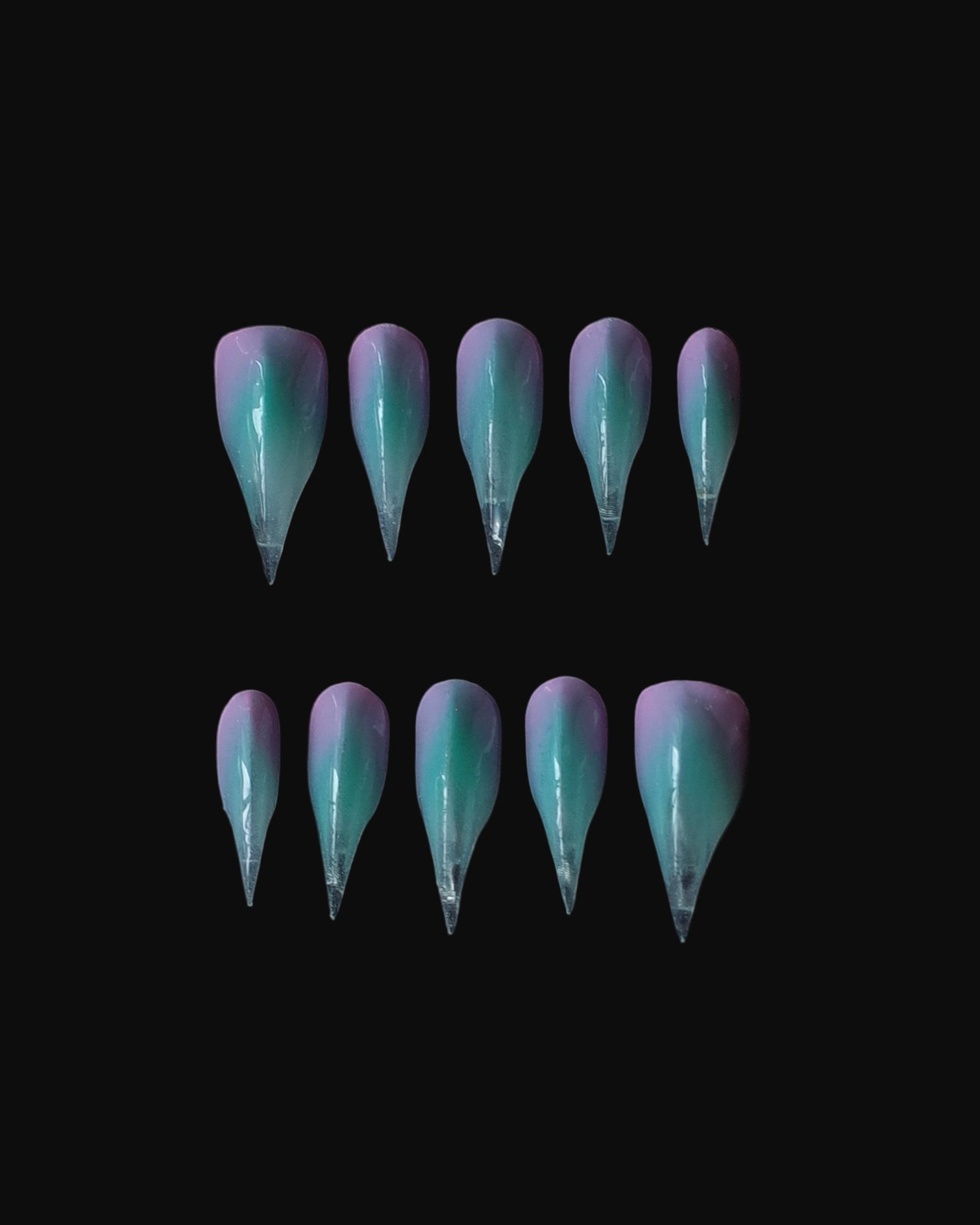 A set of 3D claw art nails, painted in gradient hues of aqua, lavender, and pink. Claw nail set display.